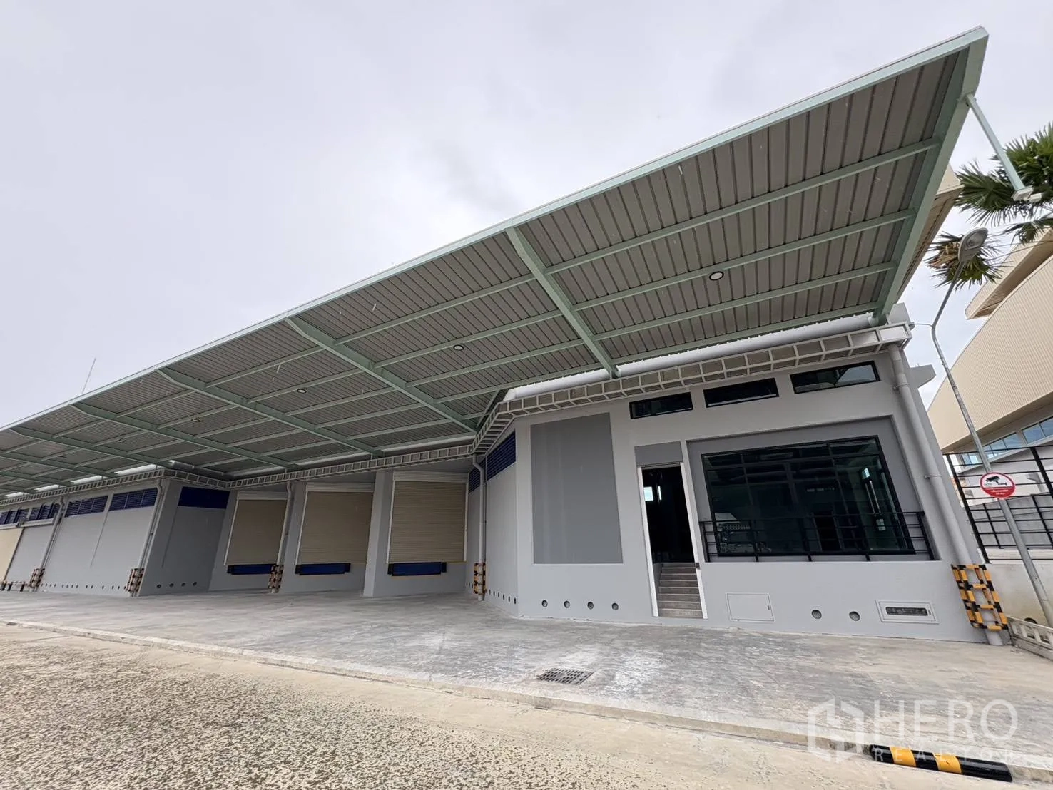 คลังสินค้า ให้เช่าในMueang Samut Prakan, Samut Prakan - ด้านนอกคลังสินค้าใหม่ พร้อมหลังคาคลุมลานขนถ่ายกว้างและประตูม้วนหลายบาน