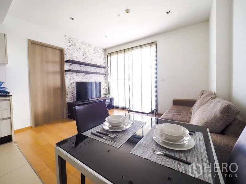 公寓 出租在Watthana, Bangkok - 通透明亮的客餐厅，沙发、电视柜与落地百叶窗。