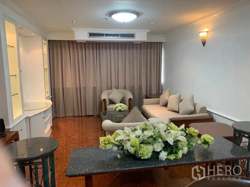 คอนโด ขายในWatthana, Bangkok - ห้องนั่งเล่นอบอุ่นพร้อมโซฟา โต๊ะกลาง เก้าอี้อาร์มแชร์ และผ้าม่านยาว