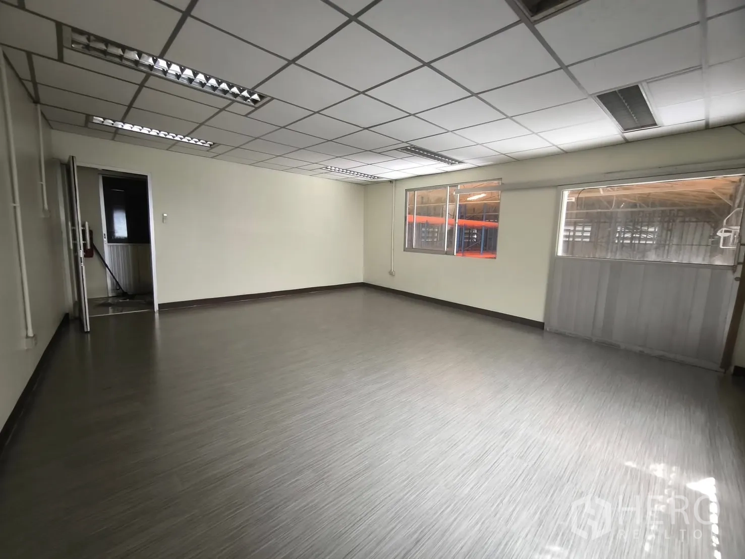 Warehouse for rent in Suan Luang, Bangkok - Spacious office room with windows overlooking the warehouse area.
