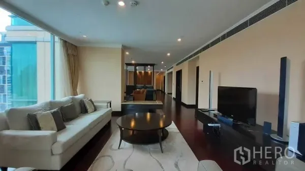 公寓 出租在Pathum Wan, Bangkok - 宽敞客厅，转角落地窗、沙发组与电视柜