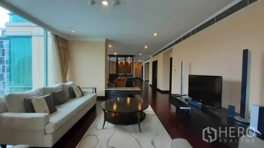 公寓 出租在Pathum Wan, Bangkok - 宽敞客厅，转角落地窗、沙发组与电视柜