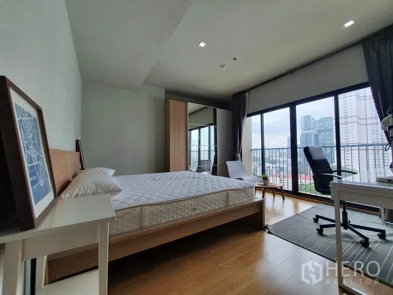 公寓 出租在Ratchathewi, Bangkok - 卧室设落地窗与书桌，享城市天际线景观。