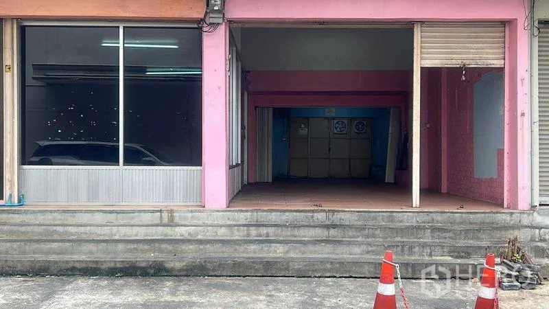 พื้นที่ขายปลีก ให้เช่าในBang Na, Bangkok - หน้าร้านสีชมพู ติดถนน พร้อมกระจกโชว์สินค้าและประตูม้วนเหนือขั้นบันไดทางขึ้น