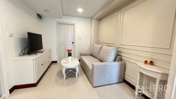 คอนโด ให้เช่าในPhra Khanong, Bangkok - ห้องนั่งเล่นอบอุ่นพร้อมโซฟาสีเทาอ่อน ตู้วางทีวี และไฟดาวน์ไลท์