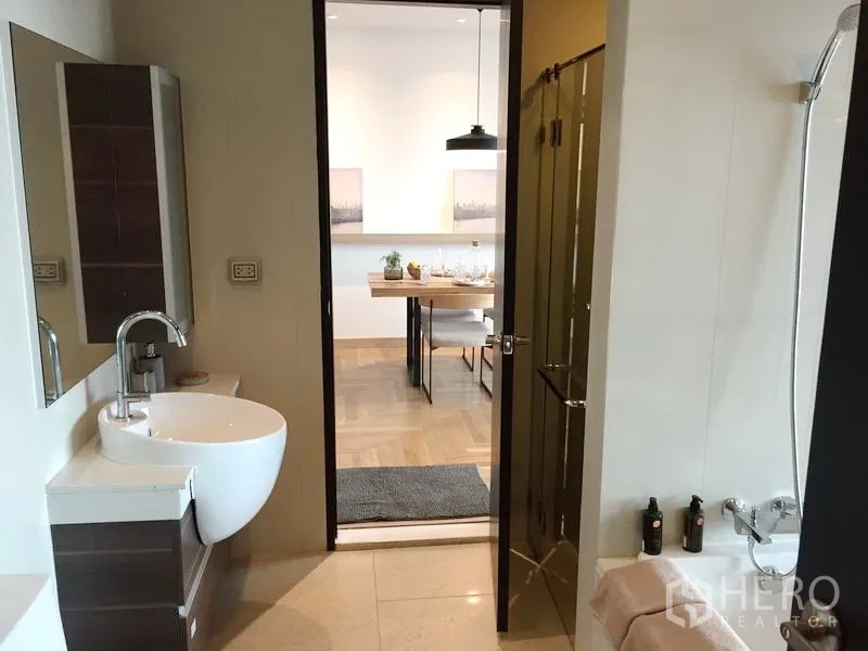คอนโด ขายในWatthana, Bangkok - ห้องน้ำสมัยใหม่พร้อมฝักบัวและอ่างล้างหน้าแบบติดผนัง ประตูเปิดสู่โซนรับประทานอาหาร
