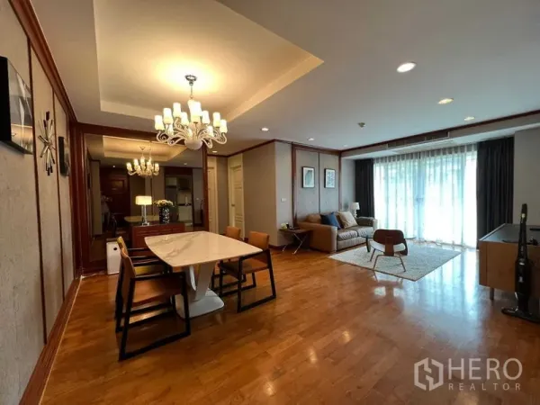 Condominium for rent or sale in Phra Khanong, Bangkok - Spacious living–dining area with wood floors and floor-to-ceiling curtains leading to a balcony.