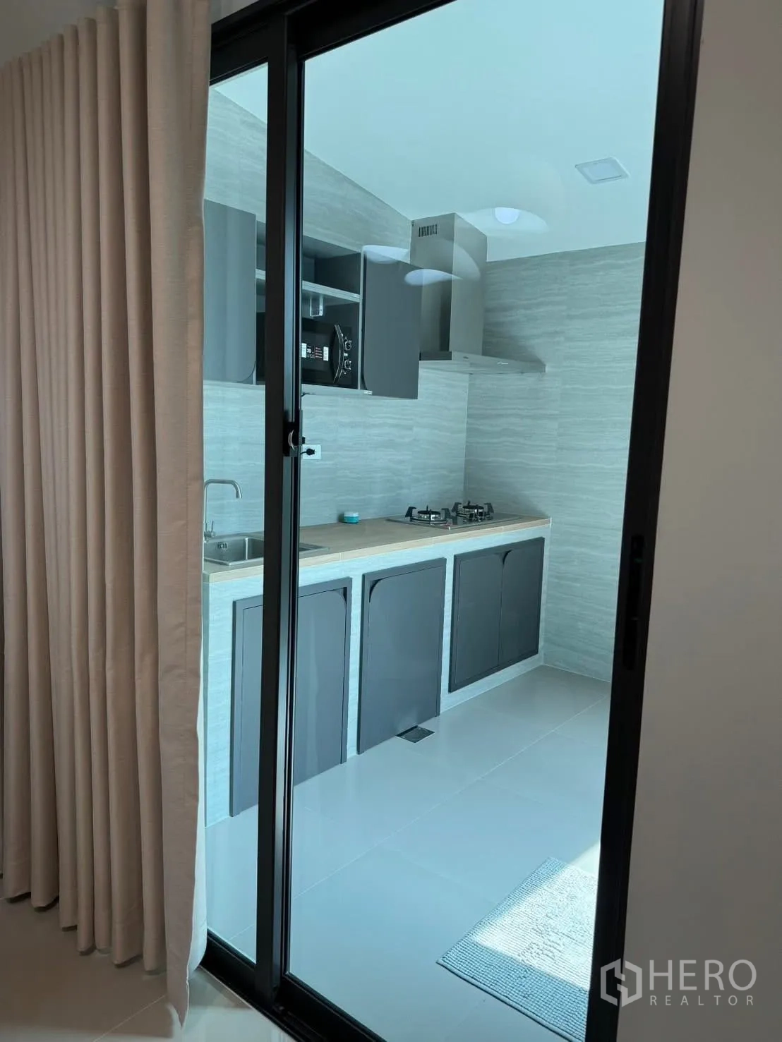 ทาวน์เฮาส์ for rent in Bang Phli, Samut Prakan - ครัวแยกกั้นประตูกระจก บิวท์อินเตาแก๊ส เครื่องดูดควัน ซิงก์ และตู้สีเทา