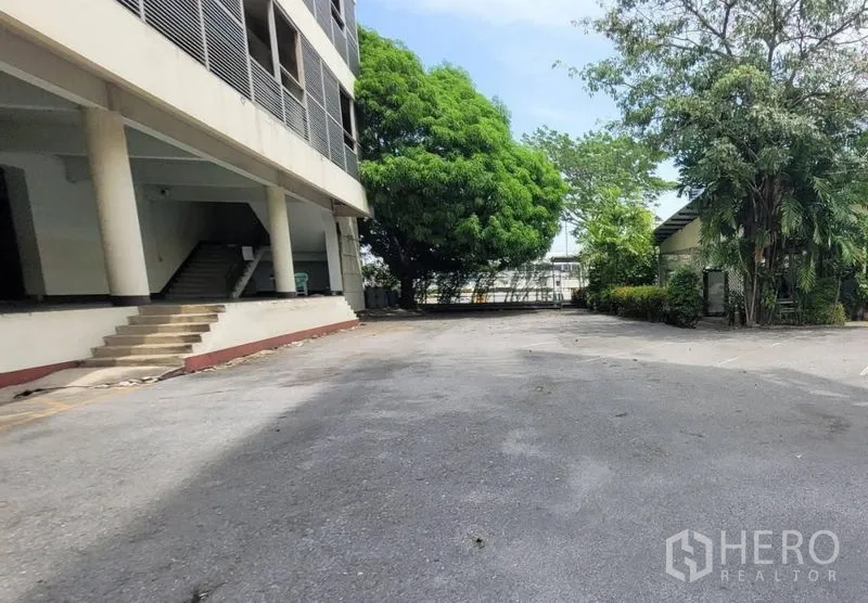 工厂 出租在Mueang Samut Prakan, Samut Prakan - 楼旁大面积车道与停车区，树木成荫