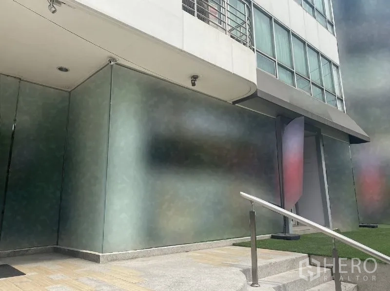 零售空间 出租在Watthana, Bangkok - 临街店面，大片磨砂玻璃、雨篷、监控摄像头及通往门口的台阶。