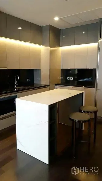 คอนโด ให้เช่าในWatthana, Bangkok - ครัวดีไซน์โมเดิร์นมีไอส์แลนด์หินอ่อน ม้านั่งบาร์ และตู้เก็บของสองโทนพร้อมไฟใต้ตู้