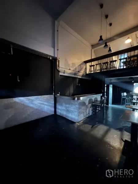店屋 出租在Watthana, Bangkok - 首层开放空间，灰纹吧台、黑色墙面与夹层座位。