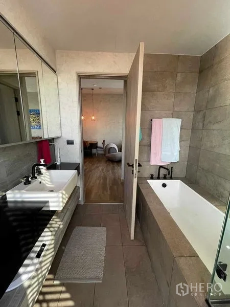 คอนโด ให้เช่าหรือขายในWatthana, Bangkok - ห้องน้ำพร้อมอ่างอาบน้ำแบบแช่ ตัวอ่างล้างหน้าคู่ และผนังกระเบื้อง