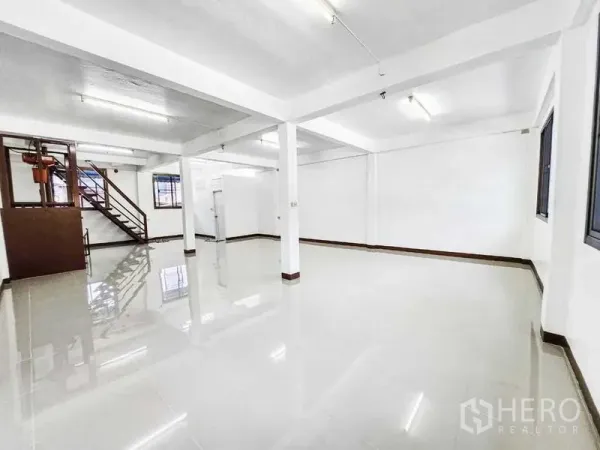 สำนักงานที่บ้าน ให้เช่าในKhlong Toei, Bangkok - พื้นที่โล่งสว่าง พื้นกระเบื้องเงา เสา และหน้าต่าง พร้อมบันไดด้านข้าง.