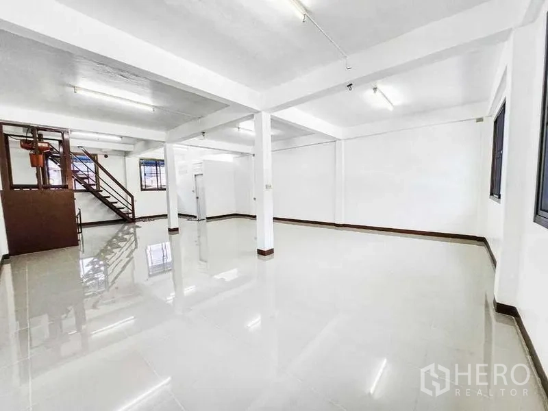 สำนักงานที่บ้าน ให้เช่าในKhlong Toei, Bangkok - พื้นที่โล่งสว่าง พื้นกระเบื้องเงา เสา และหน้าต่าง พร้อมบันไดด้านข้าง.