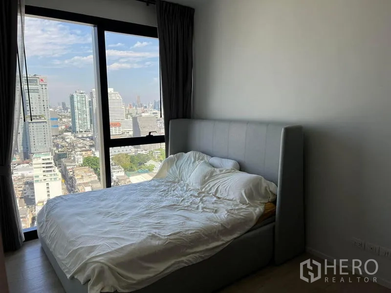 公寓 出租 - 卧室配大窗，高层俯瞰曼谷城市景观。