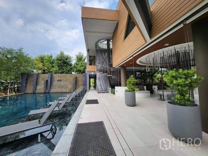 บ้าน ขายในSai Mai, Bangkok - คลับเฮาส์สไตล์โมเดิร์นบันไดเวียนติดสระว่ายน้ำยาว มีเตียงอาบแดดและกระถางต้นไม้