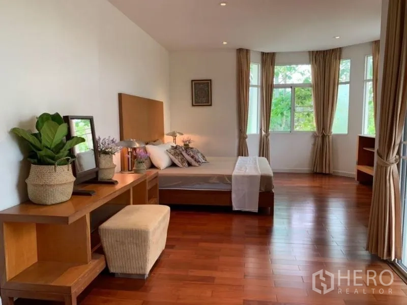 独立式住宅 出租在Lat Krabang, Bangkok - 主卧空间宽敞，木地板、书桌与湾窗。