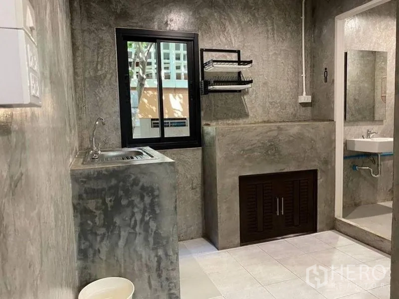 สำนักงานที่บ้าน ให้เช่าในBang Rak, Bangkok - มุมแพนทรีปูนเปลือย อ่างล้างมือ หน้าต่างและชั้นวาง ข้างห้องน้ำ