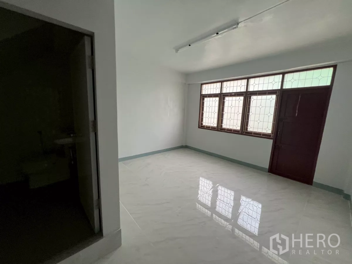 อาคารพาณิชย์ ให้เช่าในKhlong Toei, Bangkok - ห้องรีโนเวท พื้นกระเบื้องสีขาวมันวาว หน้าต่างซี่กรง และประตูห้องน้ำ.