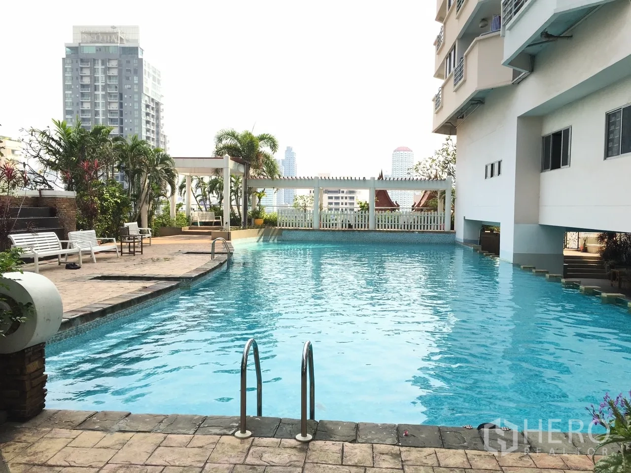 คอนโด ขายในKhlong Toei, Bangkok - สระว่ายน้ำคอนโด รายล้อมด้วยที่นั่งและต้นไม้ พร้อมฉากหลังวิวเมือง