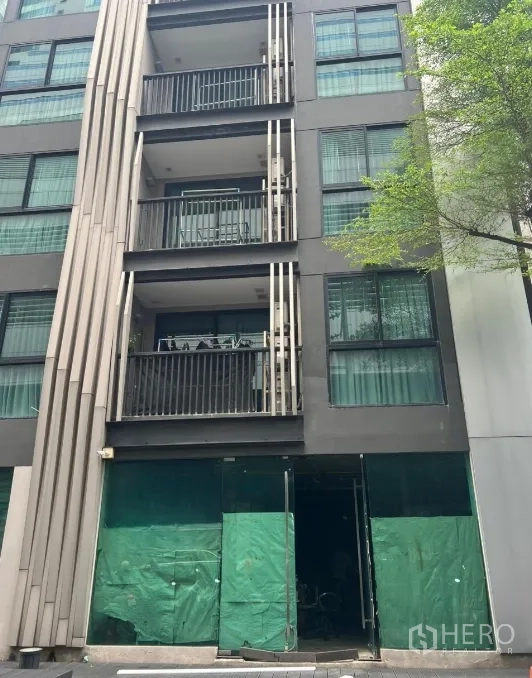 Retail Space for rent - Ground-floor retail frontage with tall glass under a modern low-rise building with balconies in the Sukhumvit–Asok area.