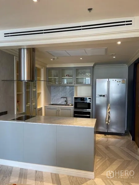 คอนโด ให้เช่าหรือขายในSathon, Bangkok - ครัวเปิดสมัยใหม่พร้อมไอส์แลนด์ ตู้กระจก และตู้เย็นสแตนเลส