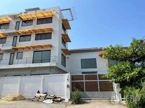 คลังสินค้า ให้เช่าในPhra Khanong, Bangkok - อาคารสำนักงานหลายชั้นติดโกดังพร้อมกันสาดสีเหลืองและประตูรั้วทางเข้า