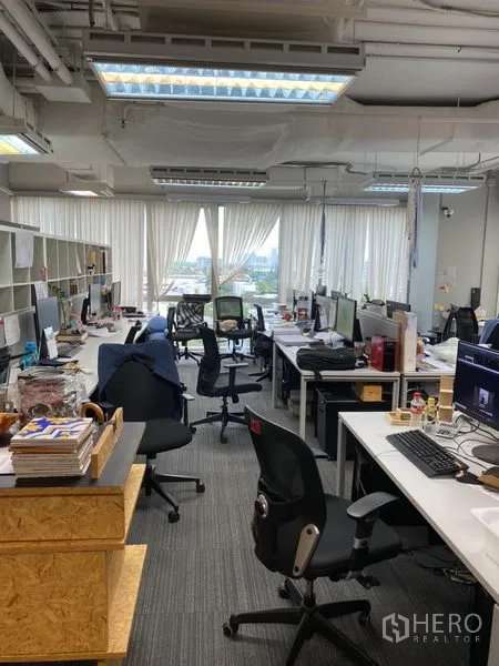 สำนักงาน ให้เช่าในKhlong Toei, Bangkok - พื้นที่ทำงานสว่าง โต๊ะหลายชุด ไฟเพดาน และวิวเมืองผ่านหน้าต่างกว้าง