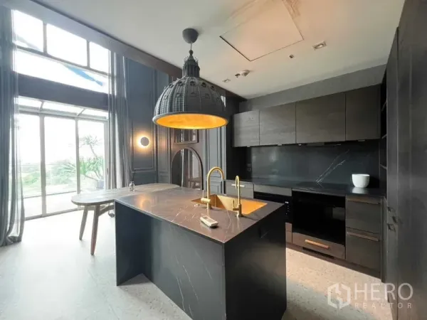 公寓 出售在Khlong Toei, Bangkok - 设计师厨房，中岛台、圆顶吊灯与通高窗户。