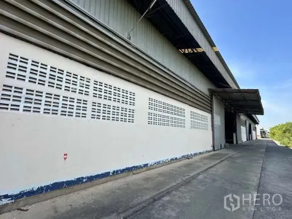 货栈 出租在Wang Noi, Phra Nakhon Si Ayutthaya - 金属外墙仓库外观，带坡道与遮雨装卸棚，天空晴朗，位于旺诺伊。