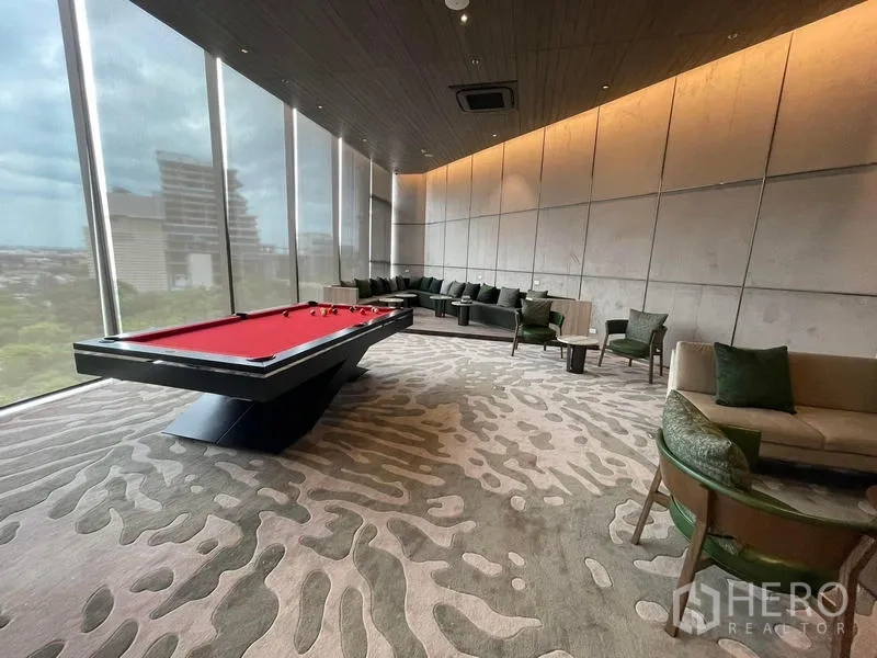 Condominium for rent in Samut Prakan - Residents’ lounge featuring a red billiards table and panoramic windows.