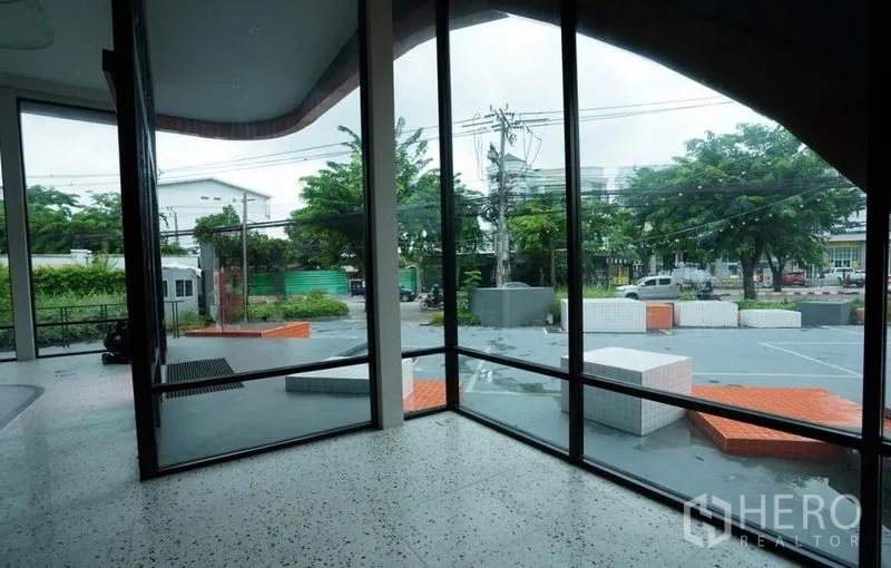 独立商业地产 出租在Bang Na, Bangkok - 室内转角落地窗，眺望前方广场与道路出入口。