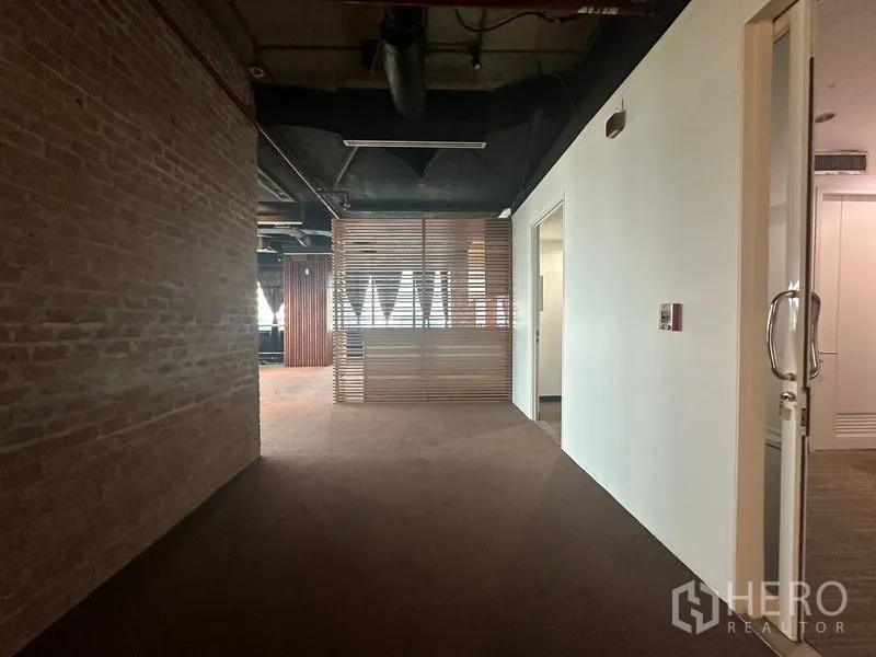 办公空间 出租在Khlong Toei, Bangkok - 接待区，裸露天花、砖墙和木格栅隔断。