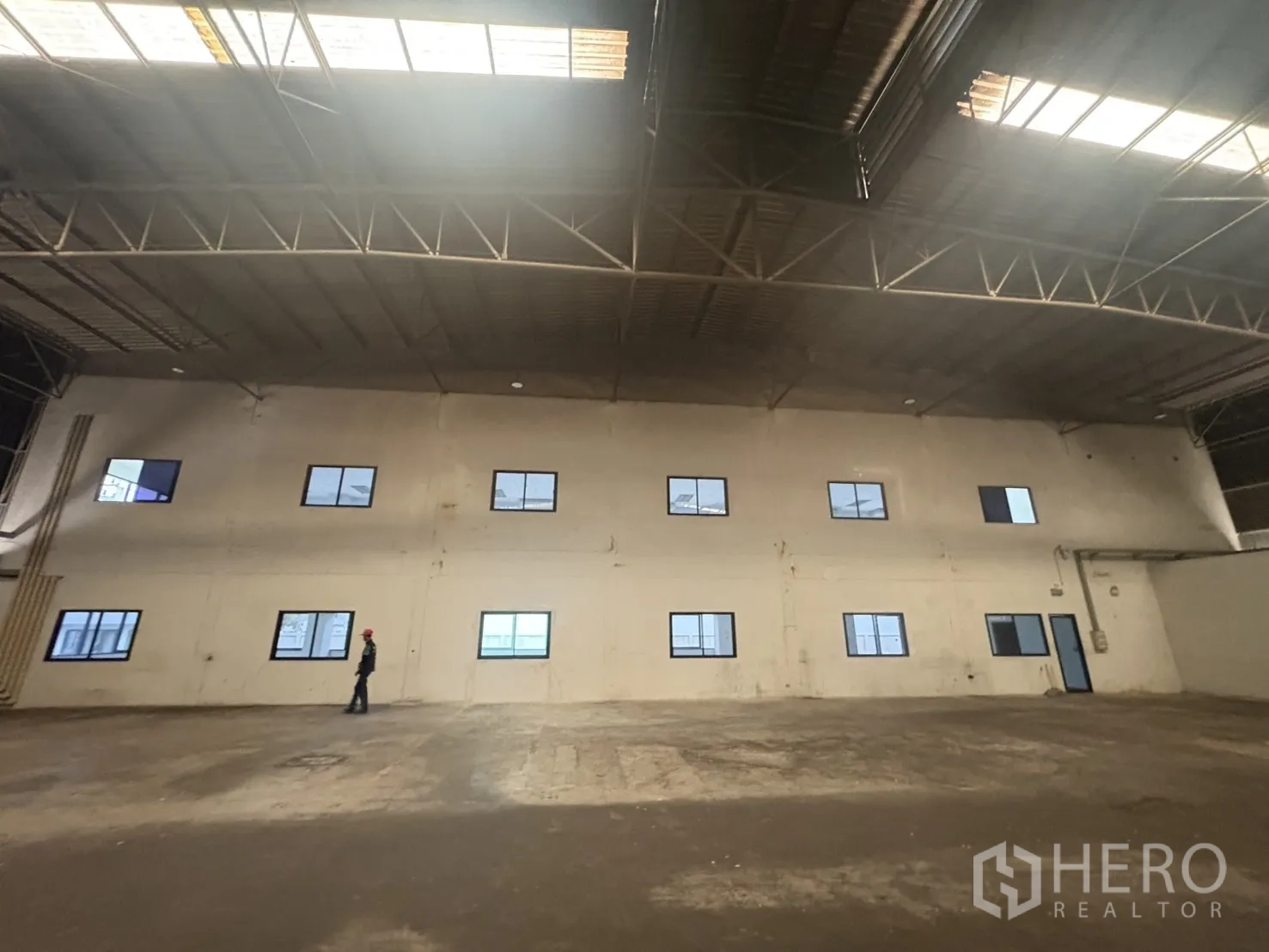 Factory for rent or sale in Samut Prakan - Another angle of the office wall inside the warehouse with windows and door.