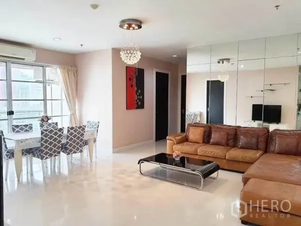 公寓 出租在Ratchathewi, Bangkok - 客餐厅一体，大窗采光，白色餐桌与棕色转角沙发，亮面地坪。