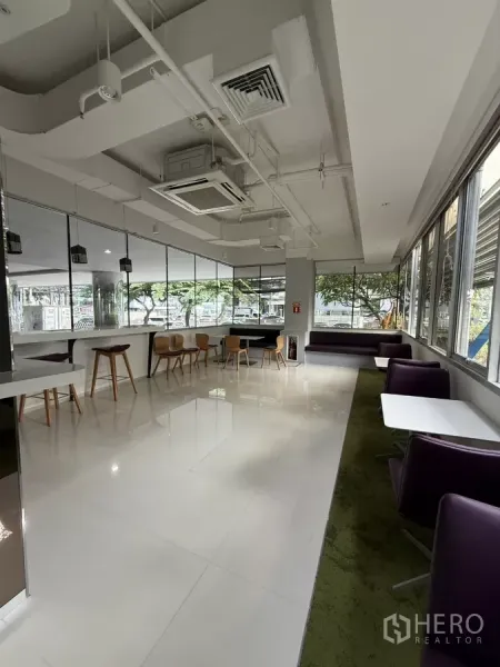 零售空间 出租在Bang Rak, Bangkok - 窗边休闲卡座与咖啡桌，高天花和嵌入式空调的角落区