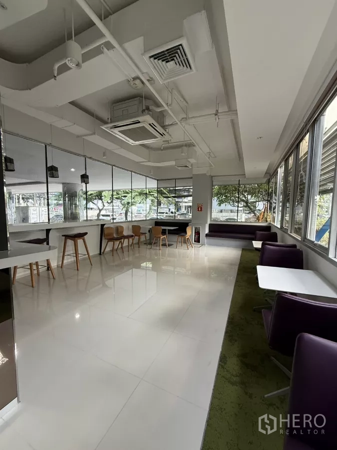 零售空间 出租在Bang Rak, Bangkok - 窗边休闲卡座与咖啡桌，高天花和嵌入式空调的角落区