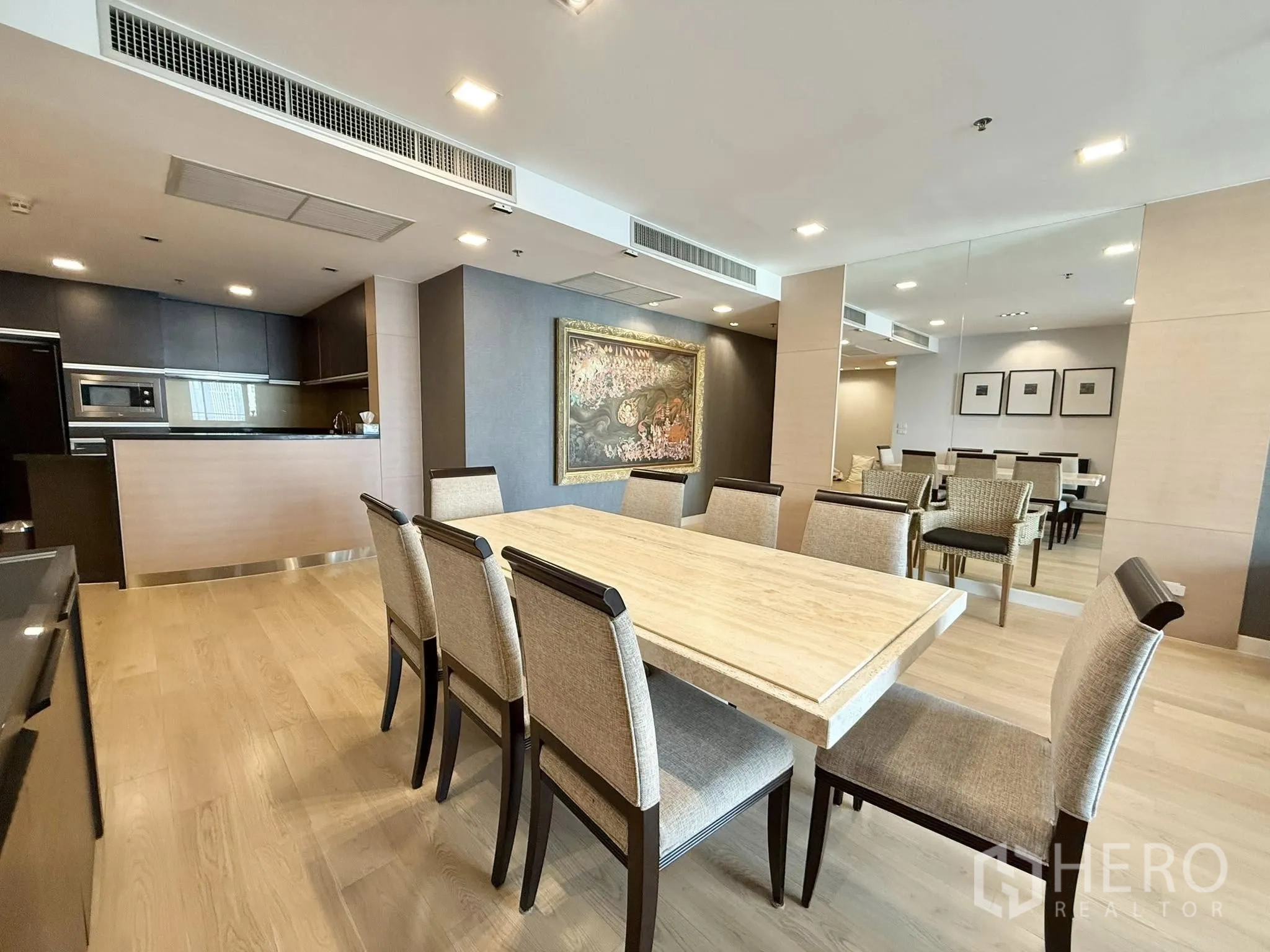 公寓 出租或出售在Sathon, Bangkok - 八人餐桌旁大镜面墙，连通现代开放式厨房。