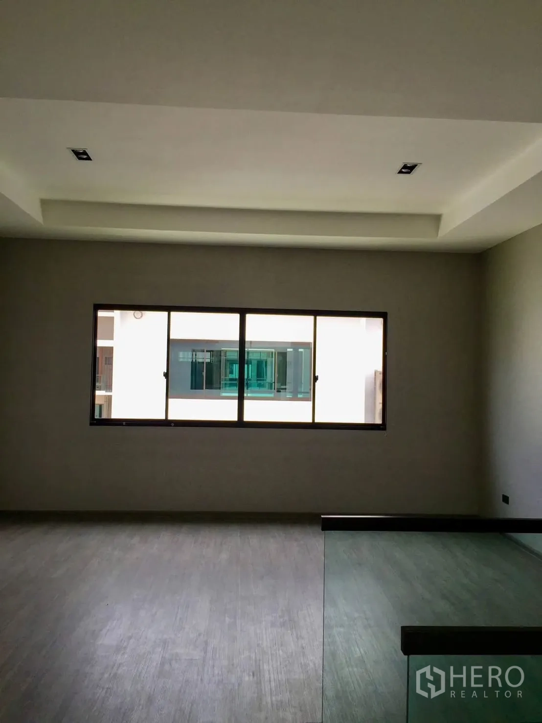 Townhouse for rent in Lat Phrao, Bangkok - Bright room with large window and recessed ceiling.
