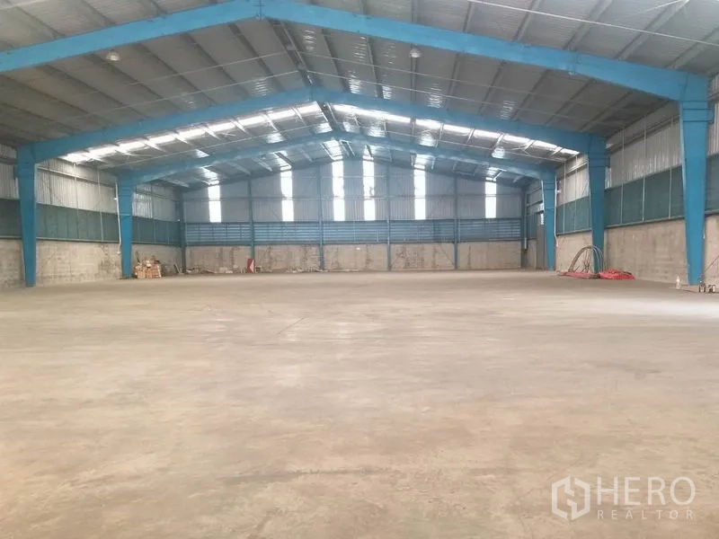 Warehouse for rent in Pathum Thani - Wide clear-span warehouse hall with smooth concrete flooring and roof lights.
