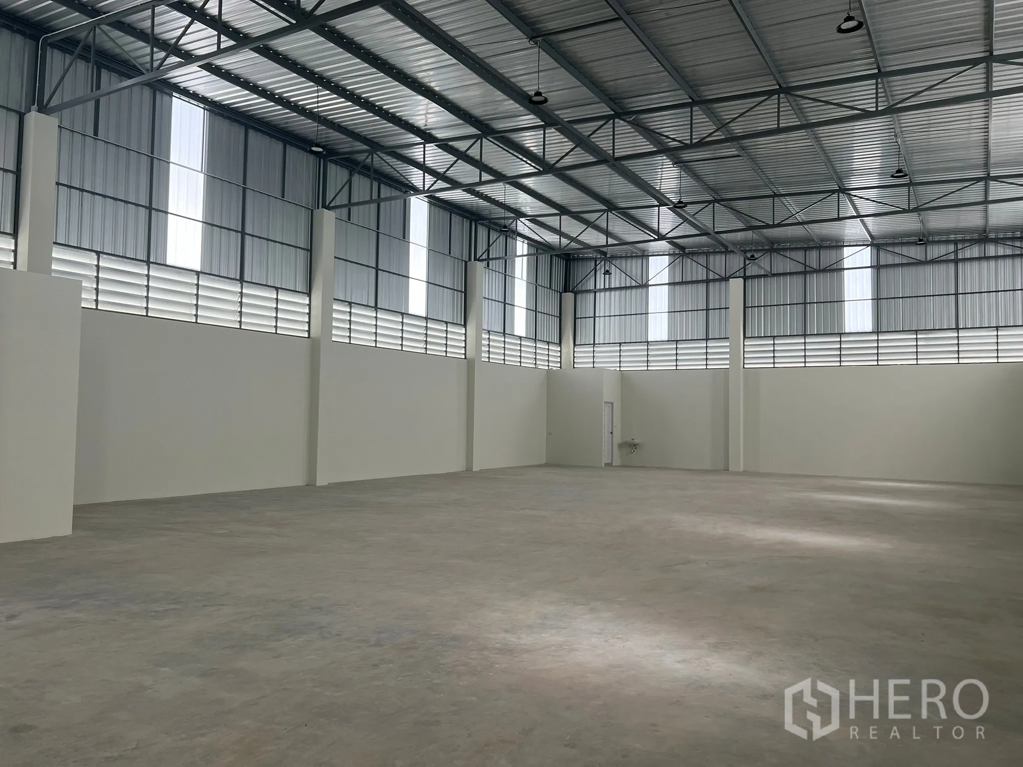 Factory for rent in Bang Phli, Samut Prakan - Spacious warehouse interior with 7–11 m high steel roof, skylights and smooth concrete floor.