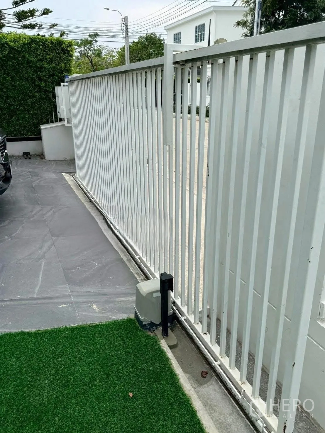 Detached House for rent in Bang Phli, Samut Prakan - White sliding driveway gate beside paved area and lawn.