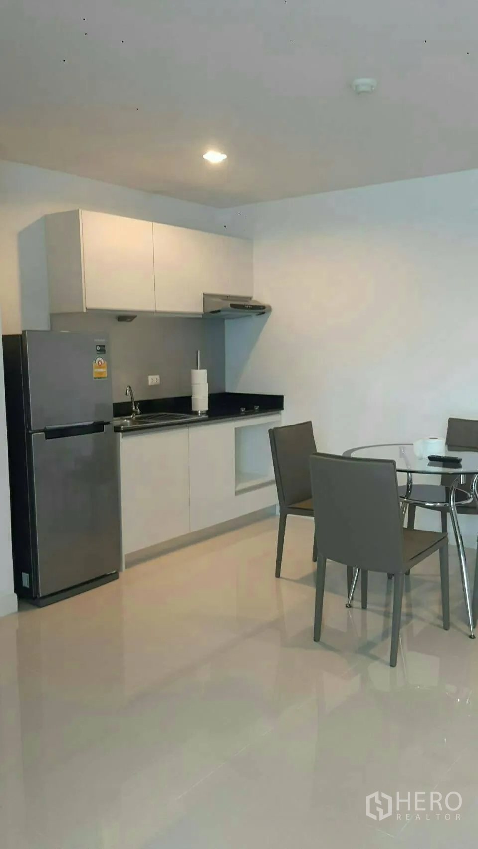 คอนโด ให้เช่าในPhaya Thai, Bangkok - ครัวแพนทรีสีขาวพร้อมตู้เย็นสแตนเลสและโต๊ะอาหารกระจกทรงกลม