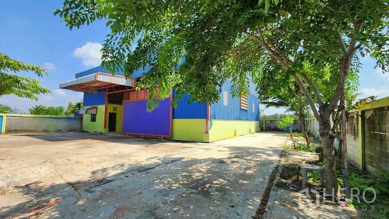 货栈 出租在Nong Chok, Bangkok - 仓库侧面，树荫下的混凝土车道与围墙。