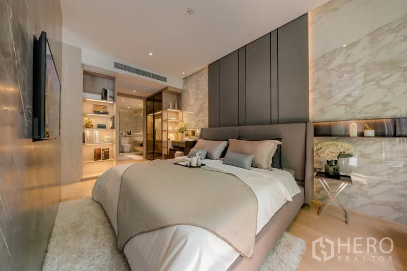 คอนโด ให้เช่าในWatthana, Bangkok - ห้องนอนมาสเตอร์หัวเตียงบุนวม ผนังเด่น และชั้นวางของบิลท์อิน