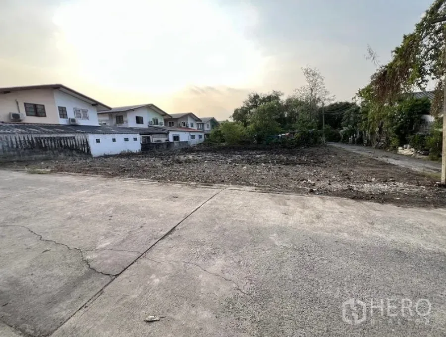 ที่ดิน ขายในBang Khen, Bangkok - มุมมองอีกด้านของแปลงที่ดินปรับเรียบ ข้างบ้านพักและต้นไม้