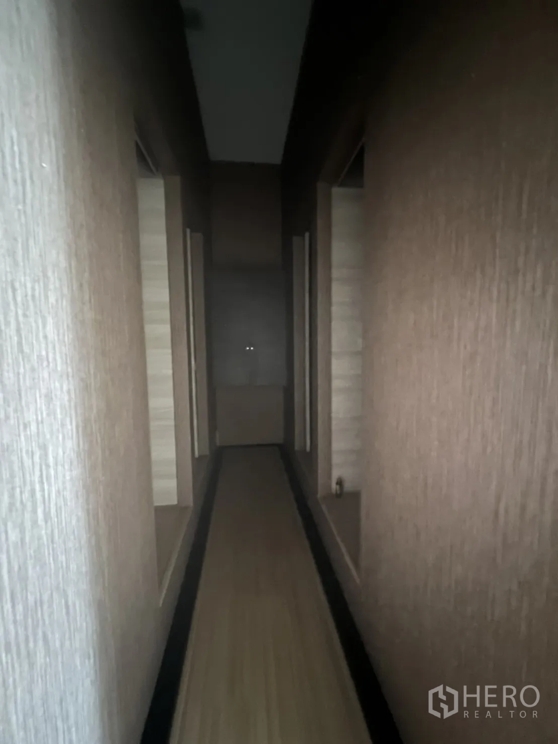 零售空间 出租在Watthana, Bangkok - 长走廊，两侧多间房门，墙面带纹理装饰。