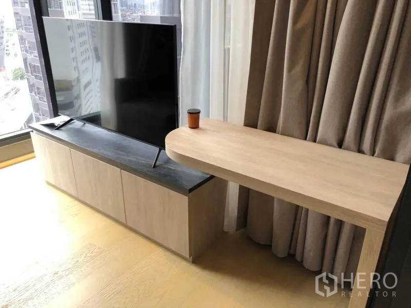 คอนโด ให้เช่าในDin Daeng, Bangkok - ห้องนั่งเล่นมีทีวีบนตู้วางไม้ และโต๊ะทำงานลอยตัวข้างหน้าต่างบานสูง