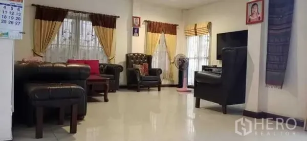 บ้าน ขายในPrawet, Bangkok - ห้องนั่งเล่นสว่าง โซฟาหนัง ทีวี และหน้าต่างขนาดใหญ่มีผ้าม่าน